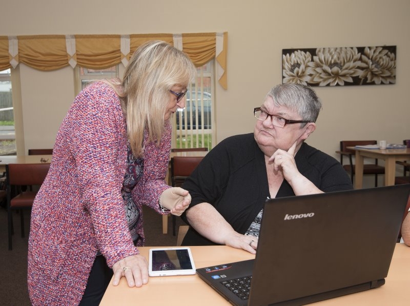 Picture of a Digital Champion helping someone learn digital skills