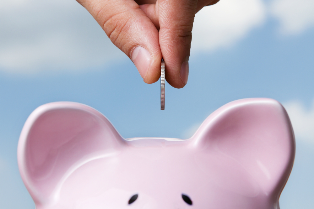 Coins going in to a piggy bank