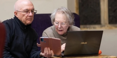 2 older people looking confused at a computer